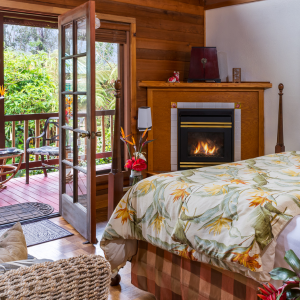 Image of king bed and fireplace at Lotus Garden Cottages on the Big island of hawaii in hawaii rain forest