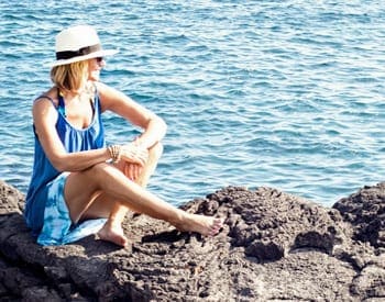 Image of woman sitting on lava rocks